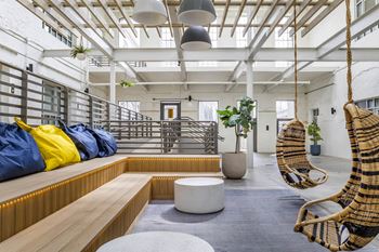 a living room with two hammock chairs and a wooden bench at Highland Mill Lofts, Charlotte, North Carolina